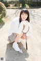 A young woman crouching down with a badminton racket.