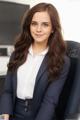 A woman in a business suit sitting in a chair.