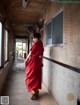 A woman in a red dress walking down a hallway.