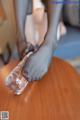 A woman's feet on a table with a bottle of water.