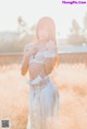A woman in a white lingerie standing in a field.