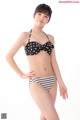 A woman in a black and white polka dot bikini.